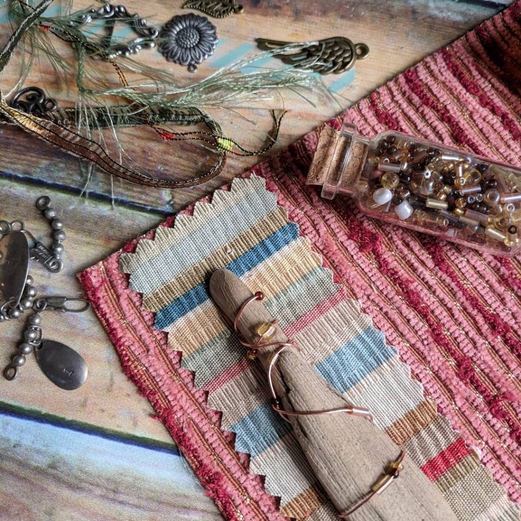 Sewing a piece of driftwood on to the fabric