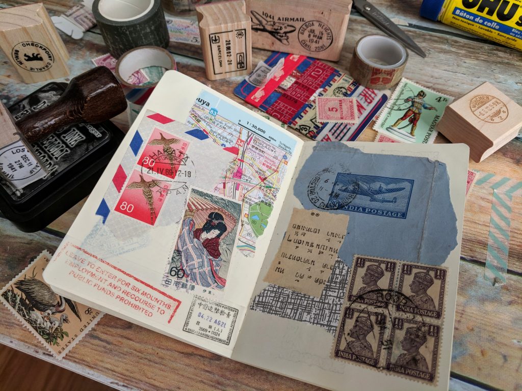 a notebook spread is covered with postage stamps