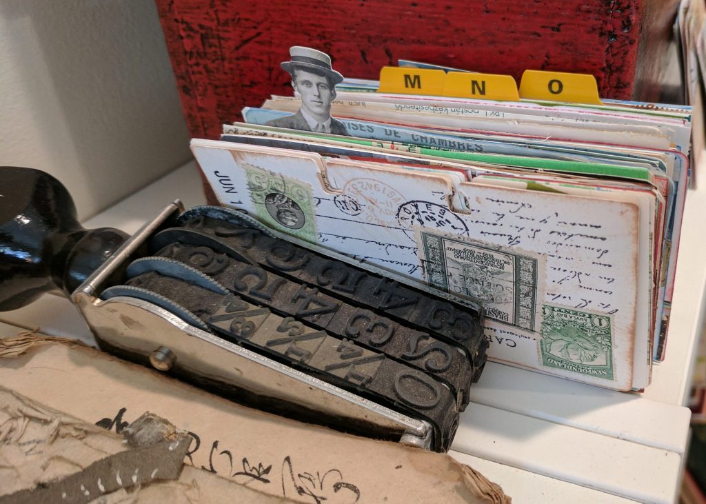 A stack of Rolodex cards are held in place by an oversized rubber stamp