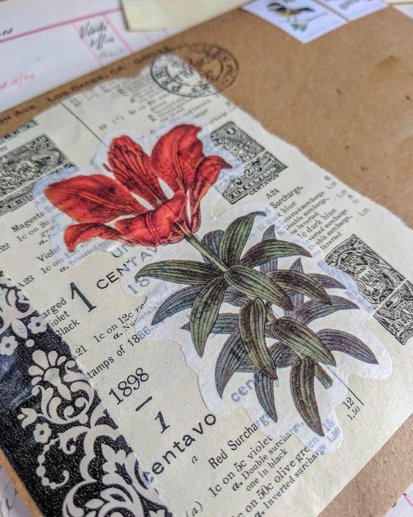 an envelope is decorated with a vintage book page and a floral image