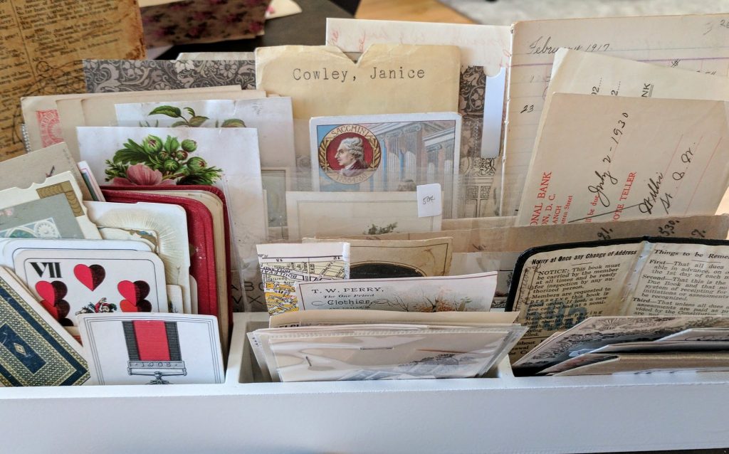 a wooden pen and paper holder is used to corral many small and oddly shaped vintage papers