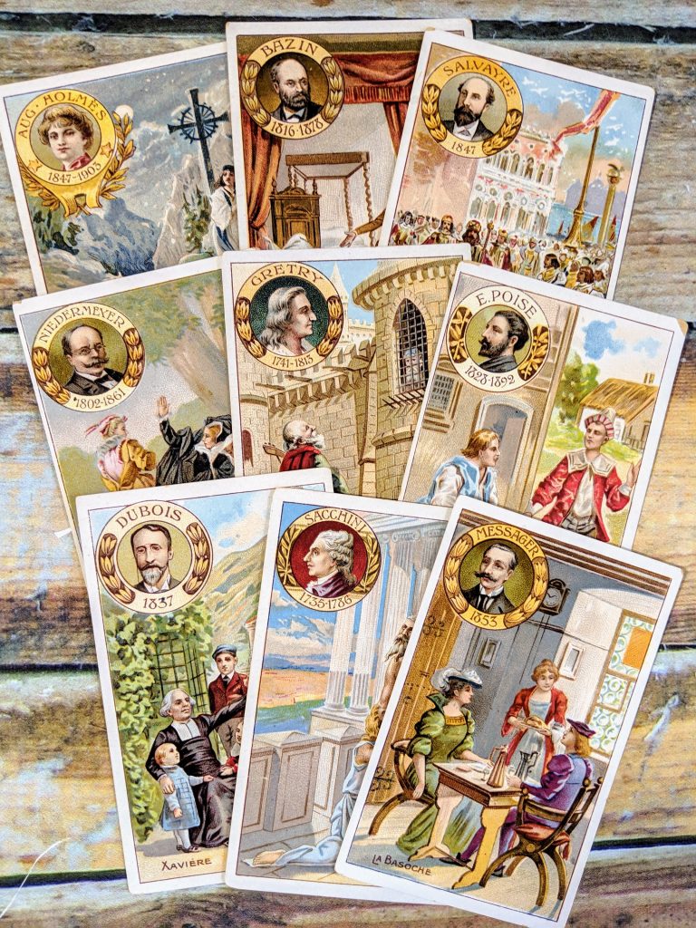A set of 9 vintage trade cards laid out on a table