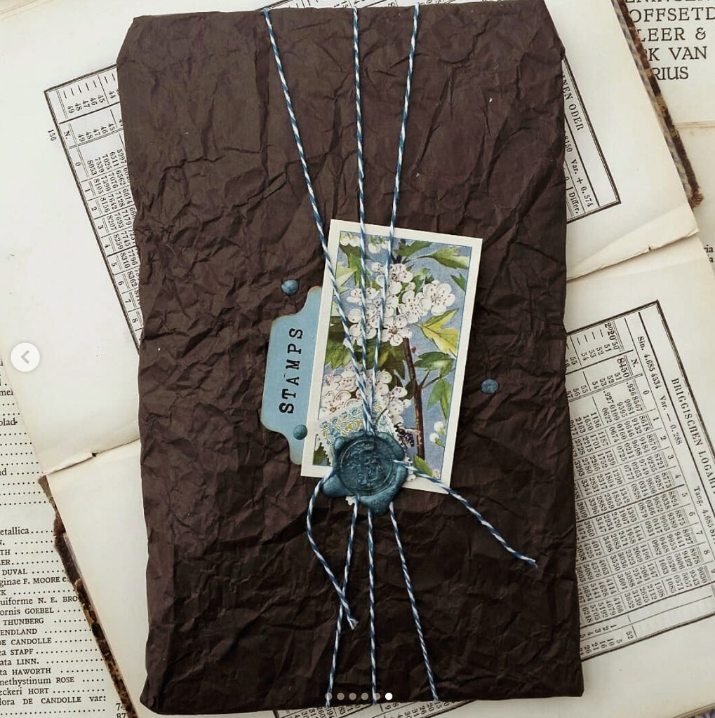 The contents are wrapped in black creche paper with a trade cards and string