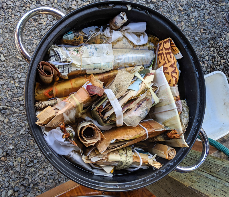 a large bunch of wrapped papers get placed in a pot of tea